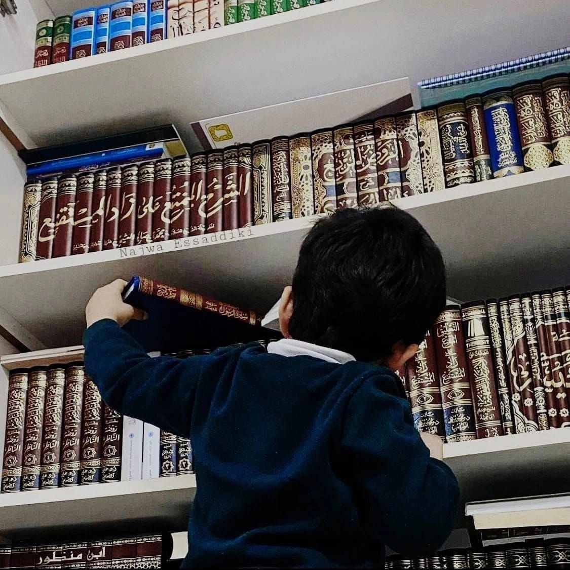 طفل يصل إلى كتاب مع شغف وحب للتعلم